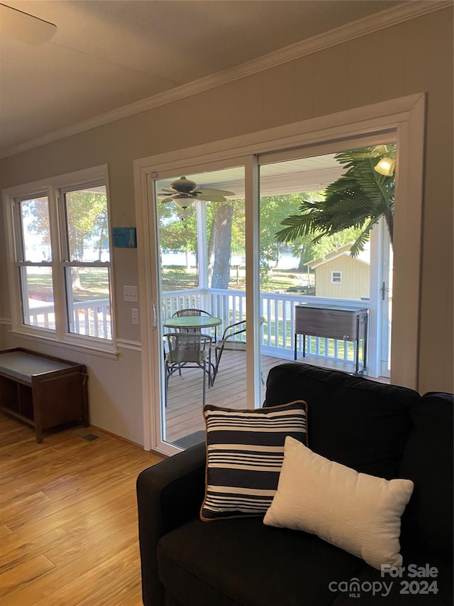 living room with light hardwood / wood-style flooring, ceiling fan, and crown molding