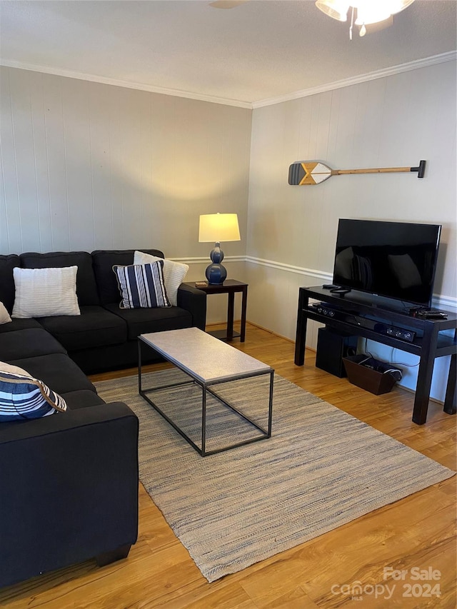 living room featuring crown molding, wooden walls, and hardwood / wood-style floors