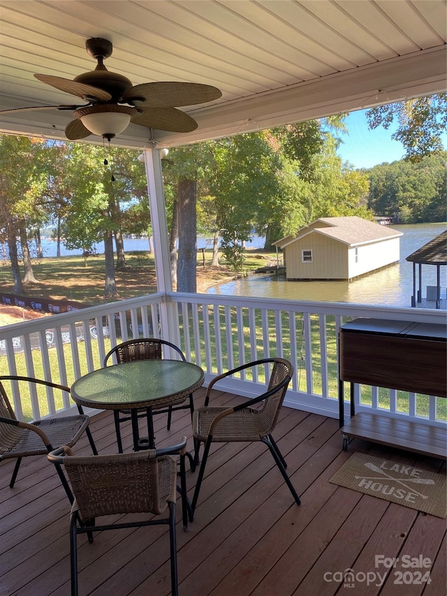 wooden deck featuring a water view and ceiling fan