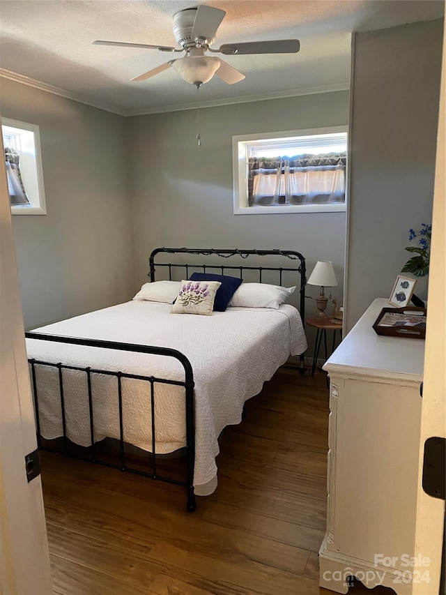 bedroom with crown molding, wood-type flooring, and ceiling fan