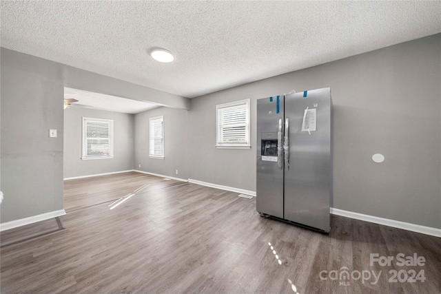 kitchen with hardwood / wood-style flooring, stainless steel fridge, and a textured ceiling