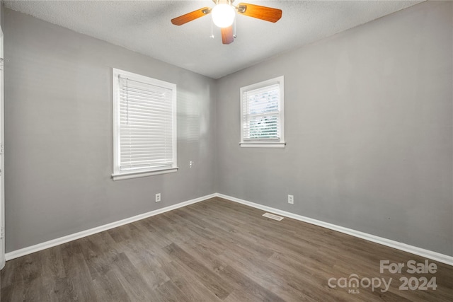 spare room featuring ceiling fan, dark hardwood / wood-style floors, and a textured ceiling