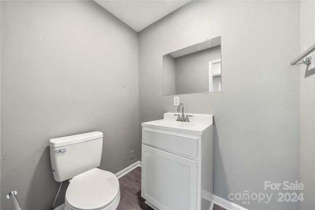 bathroom featuring vanity, hardwood / wood-style floors, and toilet