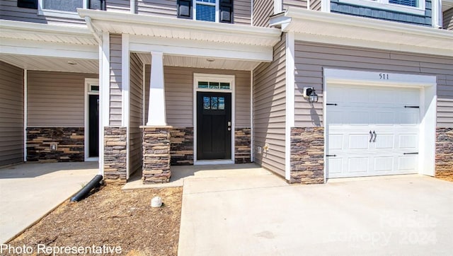 entrance to property featuring a garage and a porch