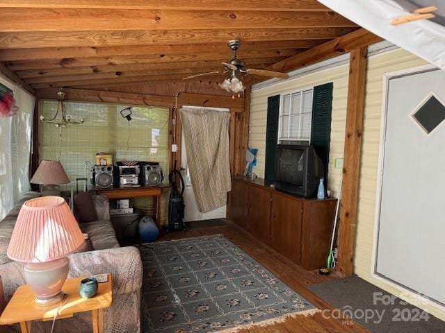 living room with ceiling fan, lofted ceiling, wood walls, dark hardwood / wood-style floors, and wooden ceiling