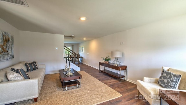 living area with recessed lighting, wood finished floors, visible vents, baseboards, and stairs