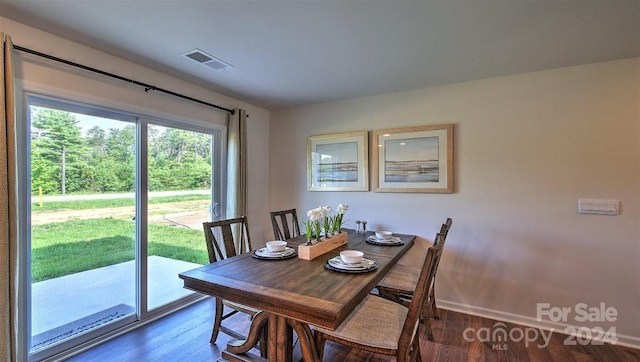 dining area with wood finished floors, visible vents, and baseboards