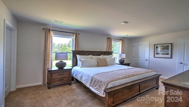 bedroom featuring visible vents, light carpet, baseboards, and multiple windows
