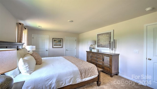 bedroom featuring baseboards and light colored carpet