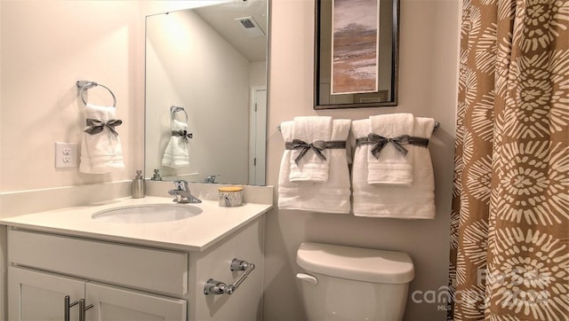full bath featuring toilet, vanity, and visible vents