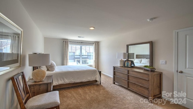 bedroom with baseboards and light carpet