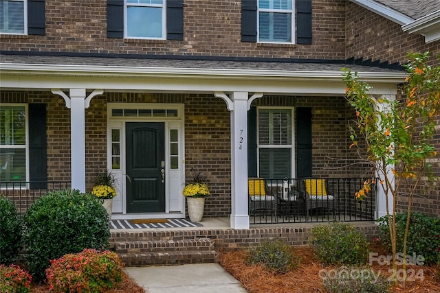 view of exterior entry featuring covered porch