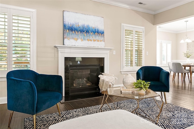 sitting room featuring hardwood / wood-style floors, a chandelier, and crown molding