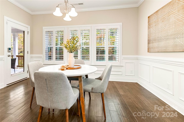 dining space featuring dark wood-type flooring, a chandelier, and ornamental molding