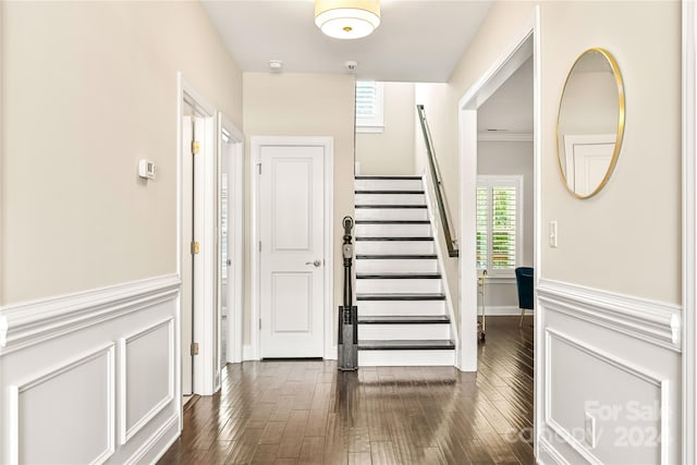 staircase featuring wood-type flooring and ornamental molding