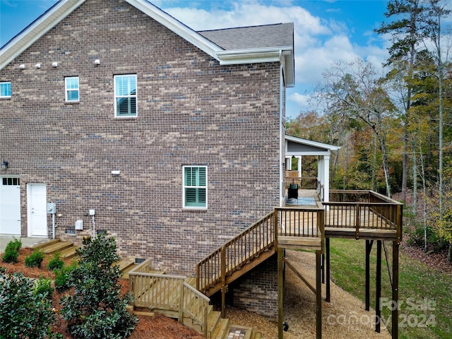 view of property exterior with a garage and a deck