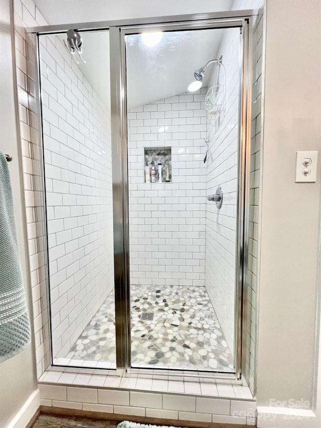 bathroom featuring a shower with door