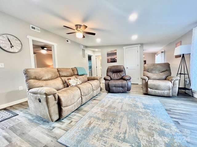 living room with light hardwood / wood-style flooring and ceiling fan