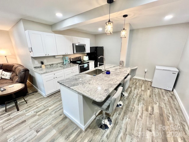 kitchen with white cabinets, sink, light wood-type flooring, and appliances with stainless steel finishes