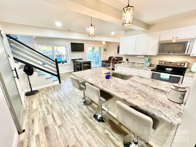 kitchen with white cabinets, a breakfast bar area, sink, and appliances with stainless steel finishes