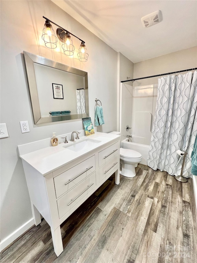 full bathroom with vanity, hardwood / wood-style flooring, toilet, and shower / tub combo with curtain