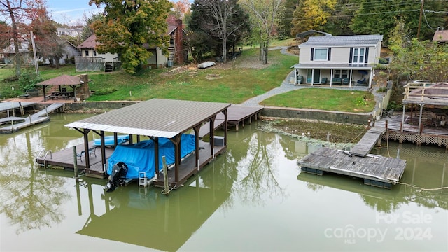 dock area with a lawn and a water view