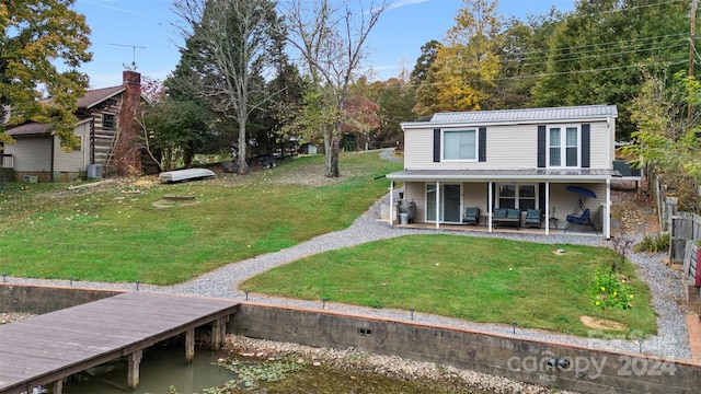 exterior space featuring central AC unit, a front lawn, a patio, and a boat dock