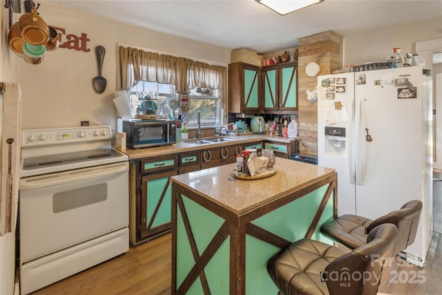 kitchen featuring sink, white appliances, and light hardwood / wood-style flooring