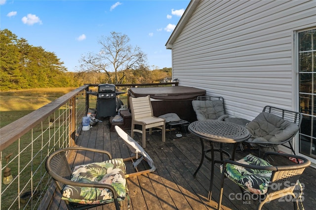 wooden deck with area for grilling and a hot tub