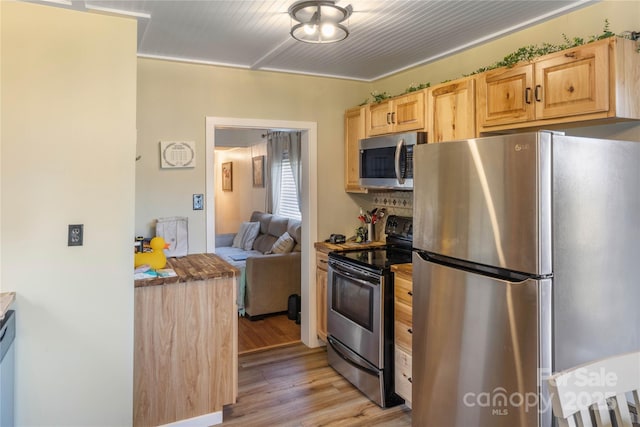 kitchen featuring stainless steel appliances, light brown cabinetry, and light hardwood / wood-style flooring