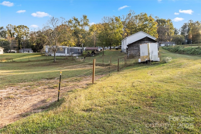 view of yard with a rural view and a storage unit