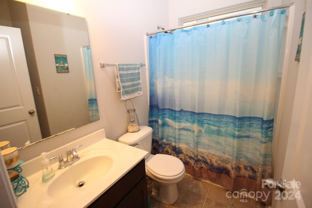 bathroom featuring vanity, a shower with shower curtain, toilet, and tile patterned floors