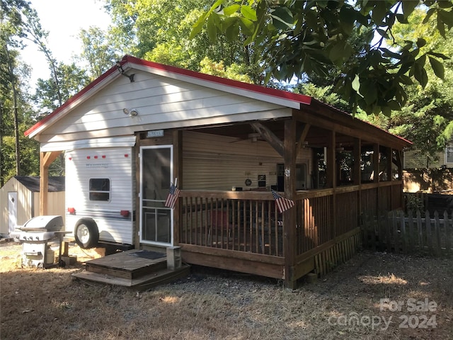 rear view of property with a storage shed