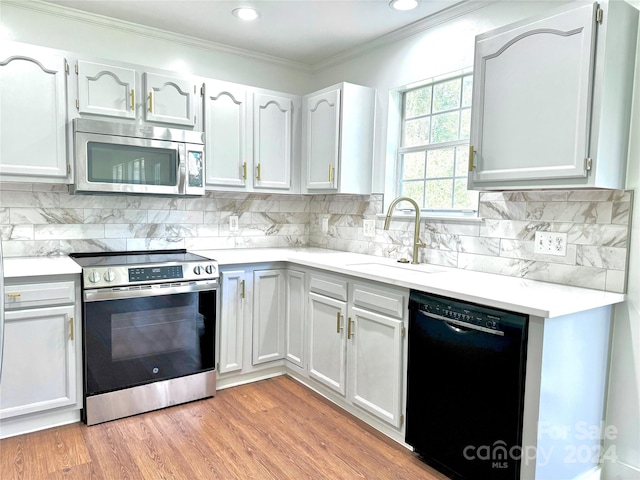 kitchen featuring light wood-type flooring, sink, stainless steel appliances, and white cabinets