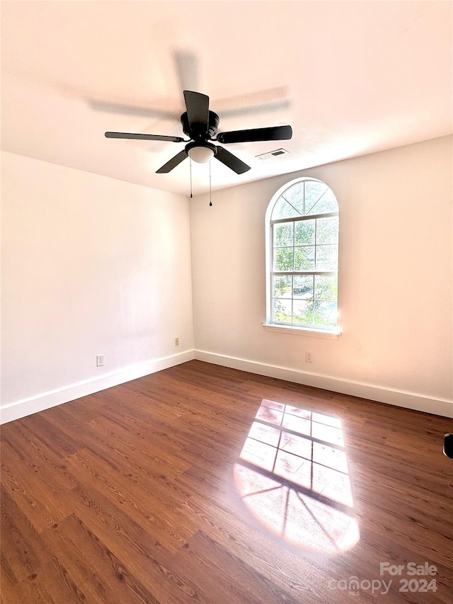 spare room featuring ceiling fan and dark hardwood / wood-style floors