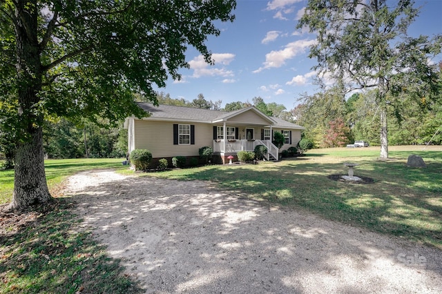 ranch-style home featuring a front lawn and covered porch