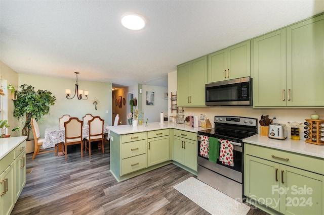 kitchen with appliances with stainless steel finishes, green cabinets, and a peninsula