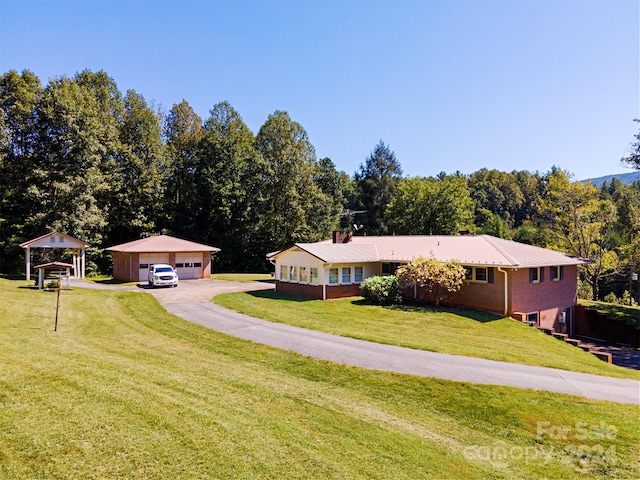 view of front of home featuring a front lawn, an outbuilding, and a garage