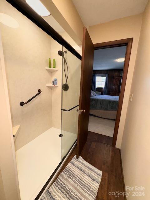 bathroom with wood-type flooring and an enclosed shower