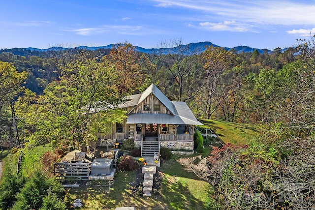 view of front of property with a mountain view, a dock, and covered porch