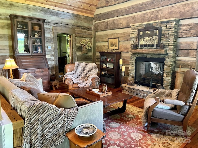 living room featuring wood-type flooring, vaulted ceiling, and a fireplace