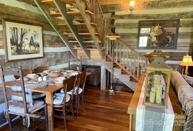 dining space with hardwood / wood-style floors and wooden walls