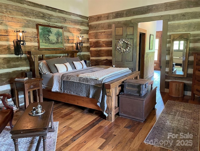 bedroom featuring hardwood / wood-style floors and wood walls