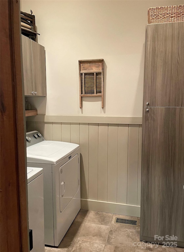 laundry room with washer and dryer and cabinets