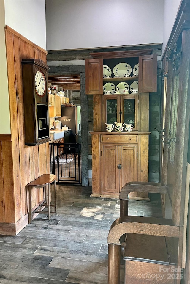 bar with stainless steel fridge with ice dispenser and dark wood-type flooring