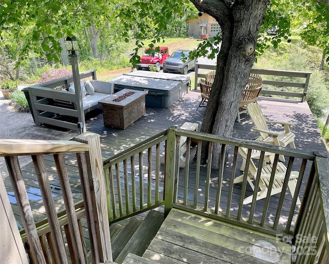 deck featuring a hot tub and a fire pit