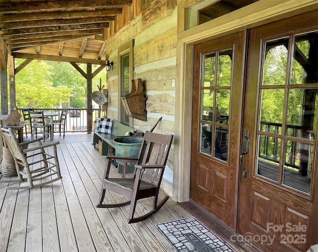 wooden terrace with a porch and french doors