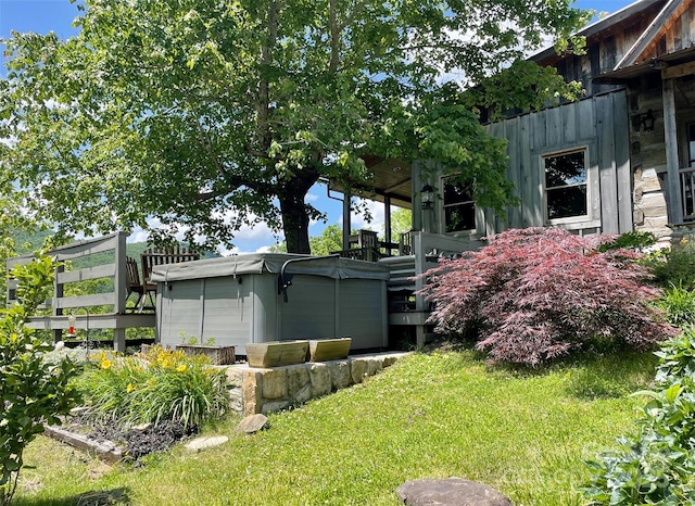 view of home's exterior featuring a hot tub and a lawn