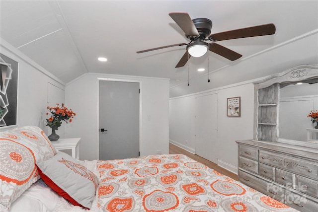 bedroom with light hardwood / wood-style floors, lofted ceiling, a closet, and ceiling fan