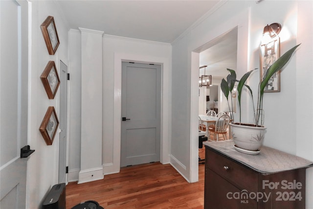 interior space with crown molding, hardwood / wood-style flooring, and a notable chandelier